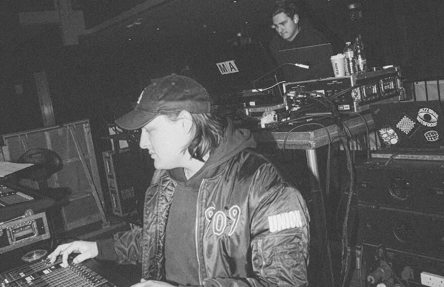 Jacob mixing at a console with a second engineer behind him